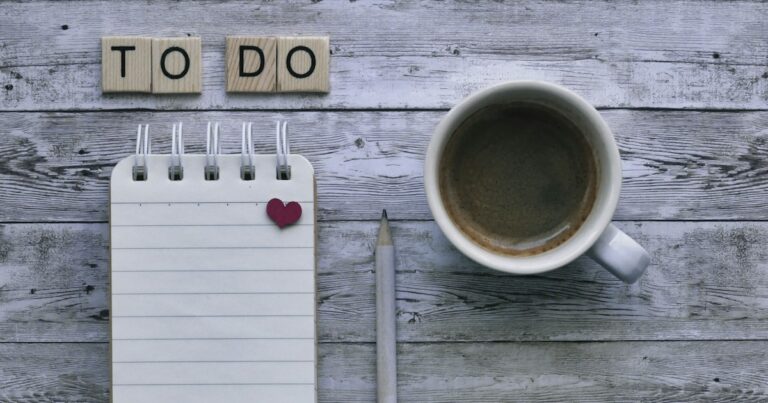 Time management for insurance agents: a to-do list notepad, pencil, and coffee on a wooden desk