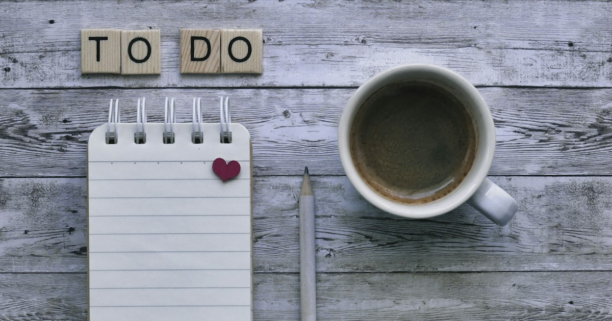 Time management for insurance agents: a to-do list notepad, pencil, and coffee on a wooden desk